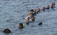 Photograph of a Newfoundland towing 12 people in the water