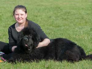 Young female sitting with a Black Newfoundland